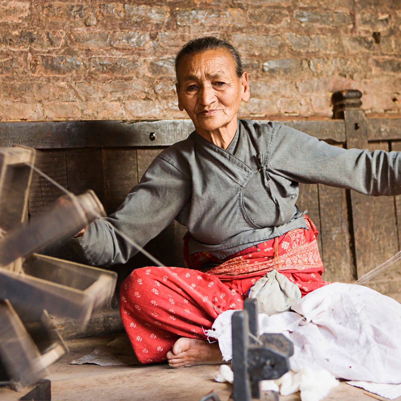 Nepali woman using spinning machine to make a wool. Bhaktapur. Kathmandu valley. Nepal.